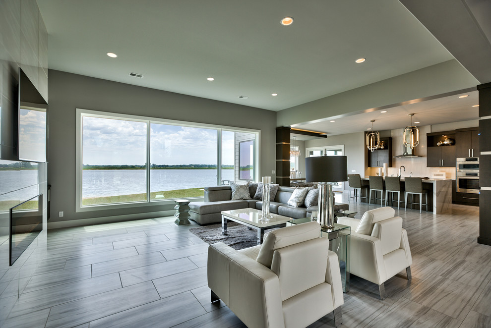 Стильный дизайн: парадная, открытая гостиная комната в стиле модернизм с горизонтальным камином, фасадом камина из плитки и телевизором на стене - последний тренд