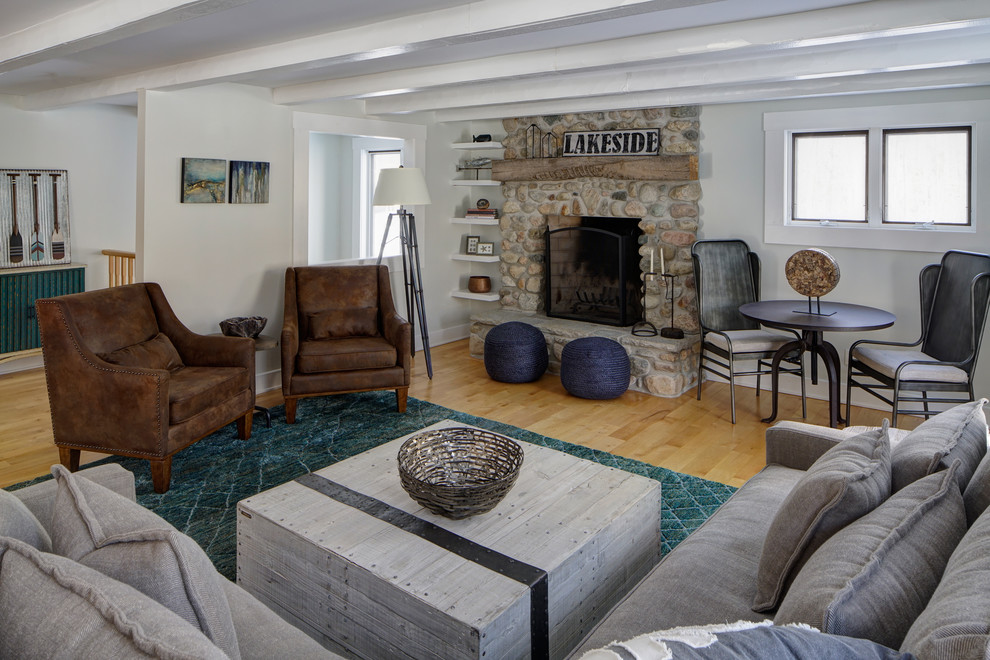 Источник вдохновения для домашнего уюта: изолированная гостиная комната среднего размера в морском стиле с белыми стенами, светлым паркетным полом, стандартным камином и фасадом камина из камня без телевизора