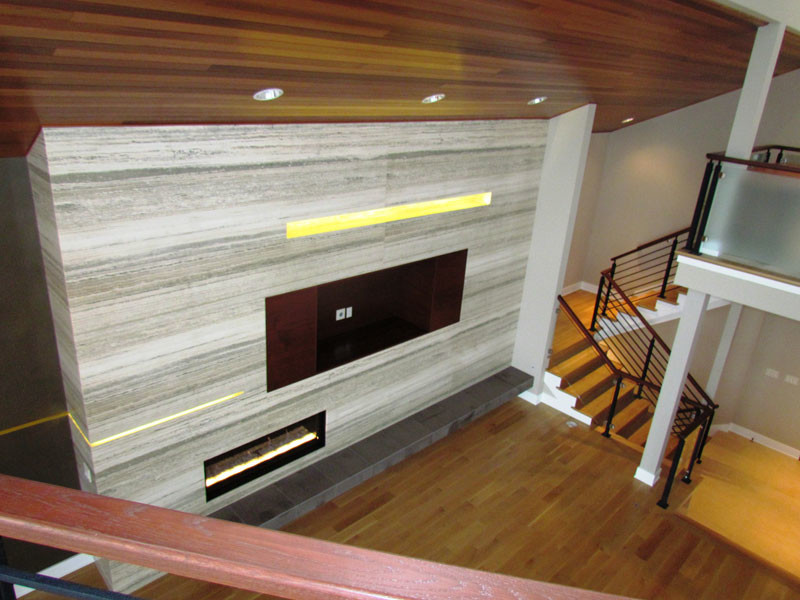 Источник вдохновения для домашнего уюта: двухуровневая гостиная комната в стиле модернизм с серыми стенами, горизонтальным камином и фасадом камина из камня