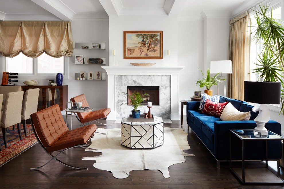 Стильный дизайн: открытая гостиная комната среднего размера в стиле неоклассика (современная классика) с белыми стенами, темным паркетным полом, стандартным камином, коричневым полом и синим диваном - последний тренд