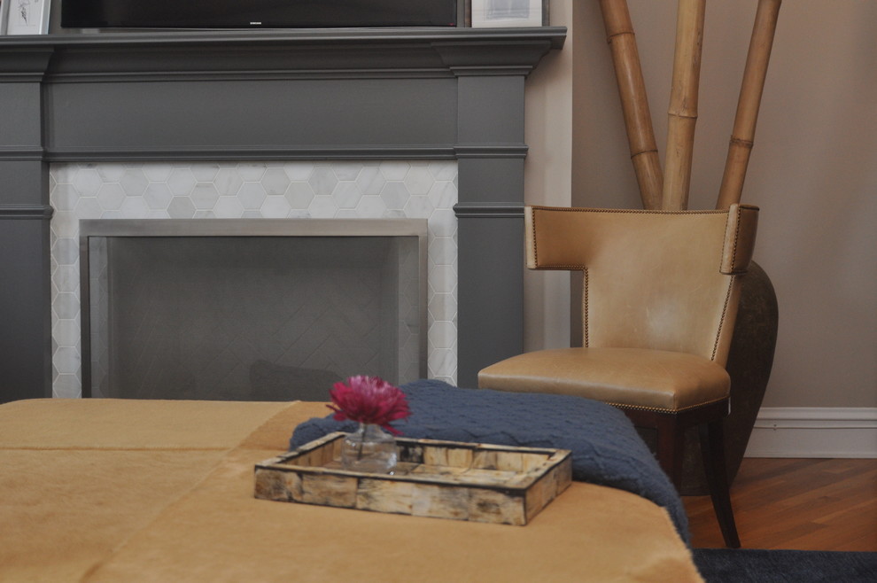 Exemple d'un salon chic avec un mur gris, parquet clair, une cheminée standard, un manteau de cheminée en carrelage et un téléviseur fixé au mur.