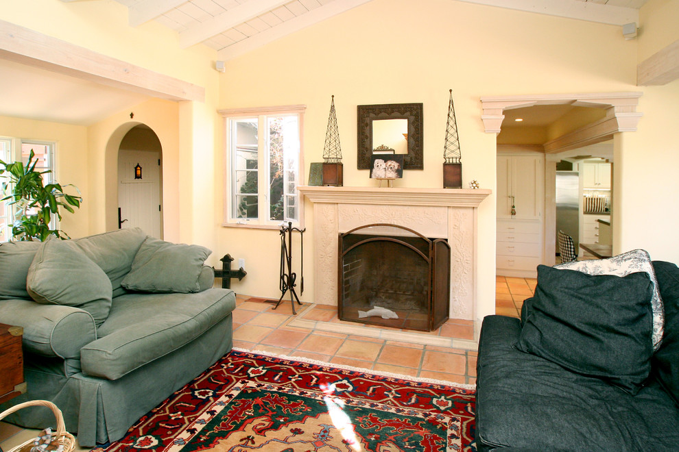 Mediterranean living room in San Francisco with yellow walls, terracotta flooring, a standard fireplace and a tiled fireplace surround.