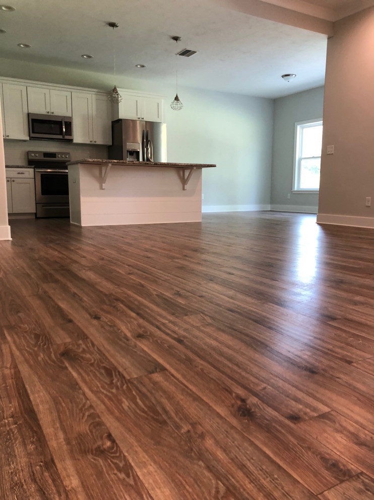 Example of a mid-sized transitional open concept laminate floor and brown floor living room design in Other