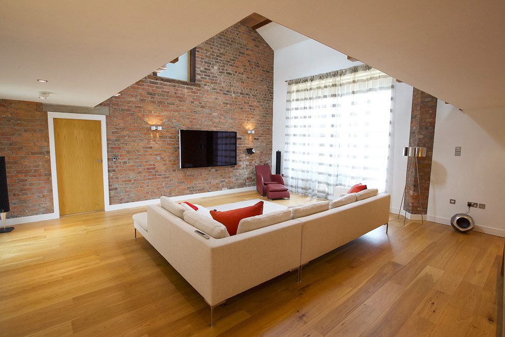 Modelo de salón con rincón musical tipo loft actual grande con suelo de madera clara y televisor colgado en la pared