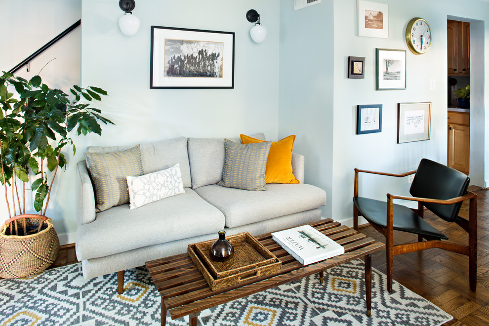 Cette photo montre un petit salon chic avec un mur bleu, un sol en bois brun, aucun téléviseur et un sol marron.