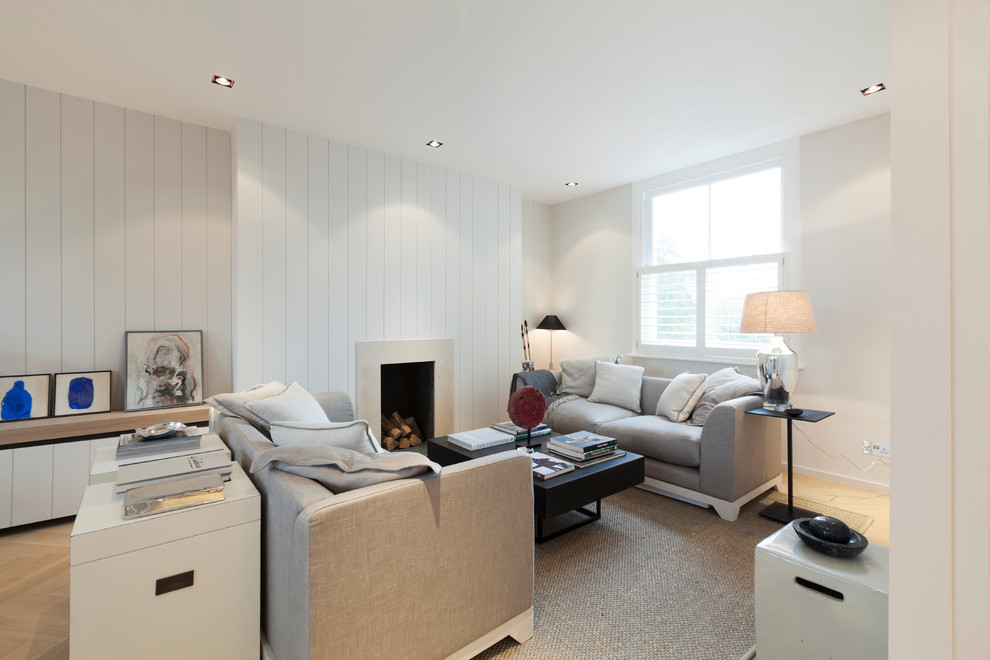 Medium sized modern formal open plan living room in London with white walls, medium hardwood flooring, a standard fireplace, a stone fireplace surround and no tv.
