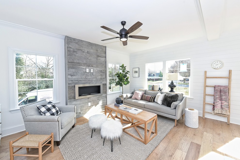 Country Wohnzimmer mit weißer Wandfarbe, braunem Holzboden, Gaskamin und braunem Boden in Charlotte
