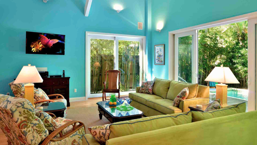 Idéer för att renovera ett mellanstort tropiskt allrum med öppen planlösning, med blå väggar och mellanmörkt trägolv