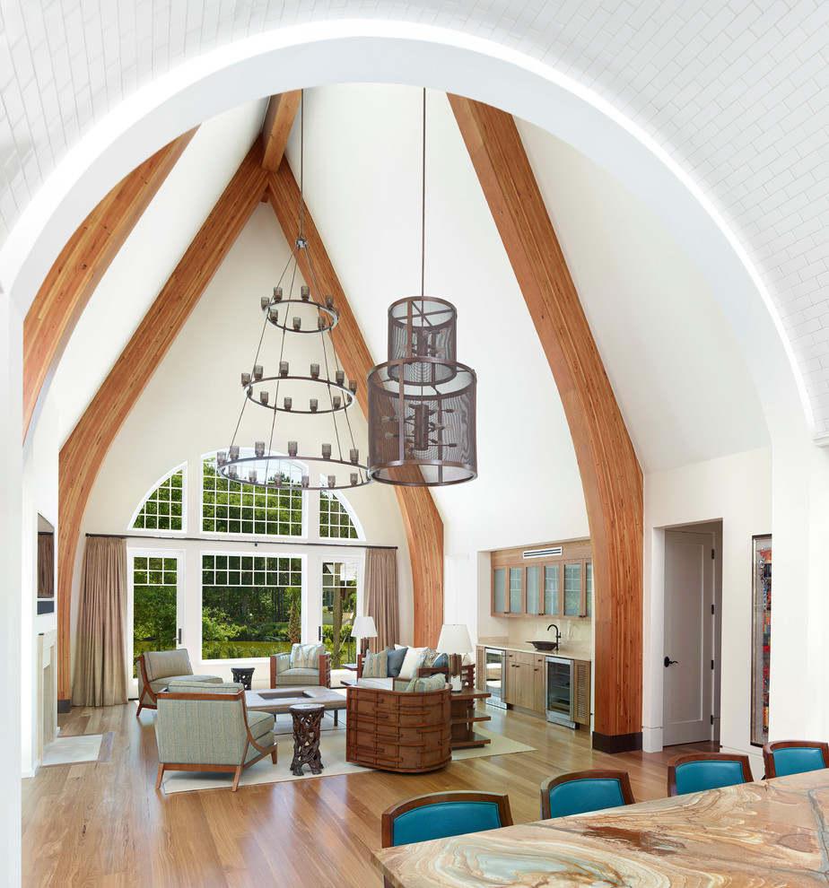 Immagine di un soggiorno chic aperto con angolo bar, pareti bianche, pavimento in legno massello medio e pavimento marrone