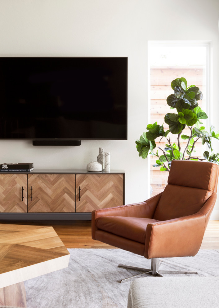 Inredning av ett modernt mellanstort allrum med öppen planlösning, med ett finrum, svarta väggar, mellanmörkt trägolv, en väggmonterad TV och brunt golv