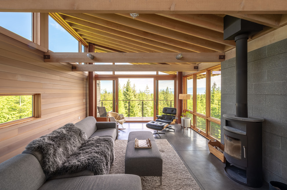 Rustikales Wohnzimmer mit Betonboden, Kaminofen und grauem Boden in Seattle