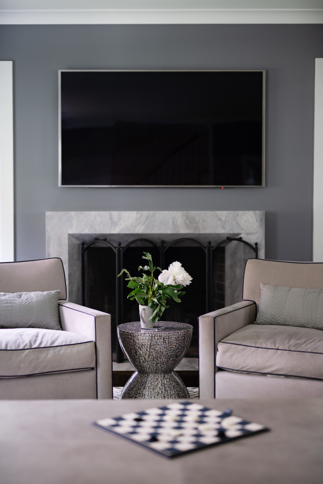 Modelo de salón cerrado moderno de tamaño medio con paredes grises, moqueta, todas las chimeneas, marco de chimenea de piedra y televisor colgado en la pared