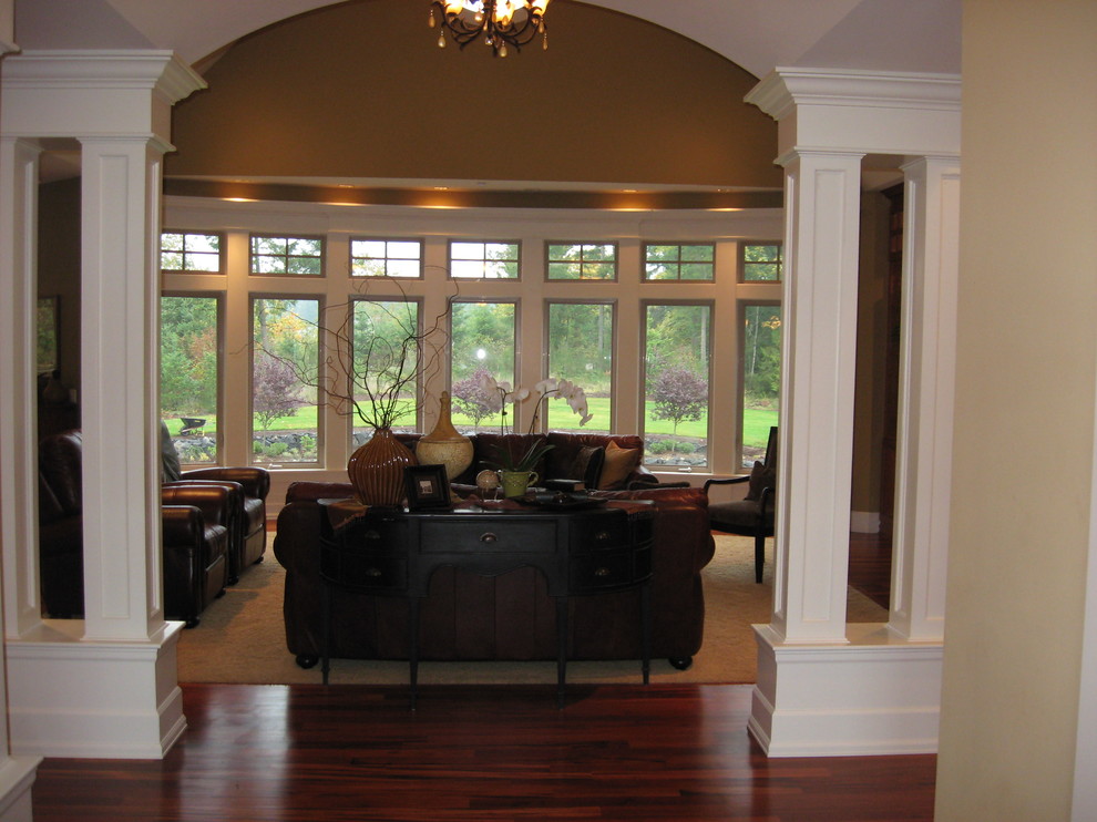 Aménagement d'un salon classique de taille moyenne et ouvert avec une salle de réception, un mur multicolore et un sol en bois brun.