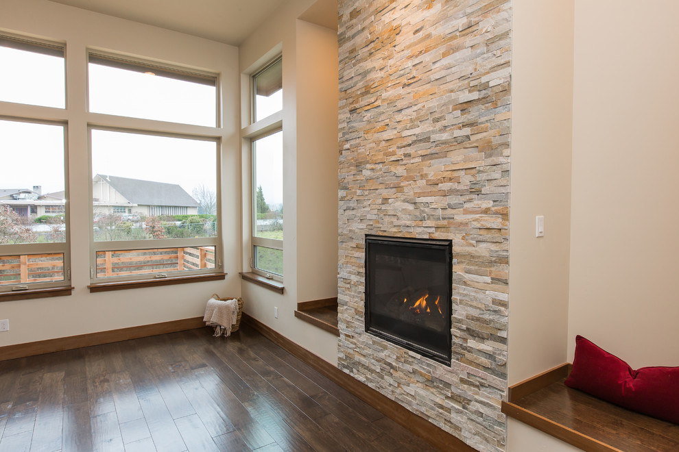 Foto de salón contemporáneo grande con paredes beige, suelo de madera oscura, todas las chimeneas y marco de chimenea de piedra