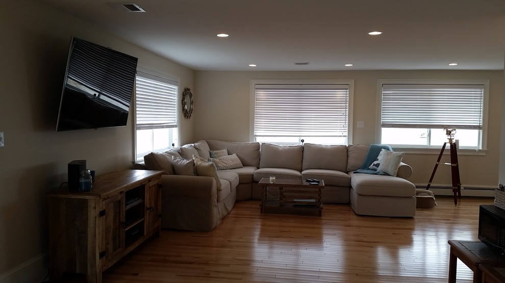 Großes, Offenes Maritimes Wohnzimmer mit Hausbar, beiger Wandfarbe, hellem Holzboden und TV-Wand in Boston