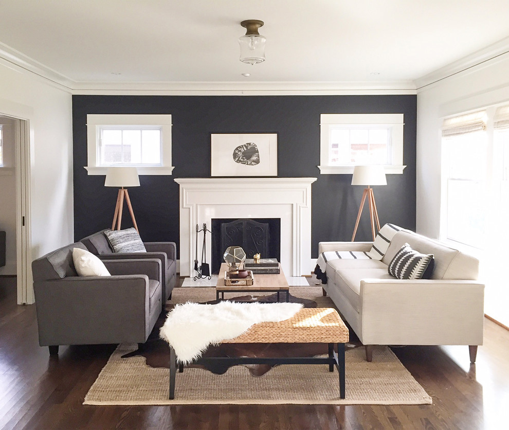 Foto di un grande soggiorno minimalista aperto con sala formale, pareti nere, parquet scuro, camino classico e cornice del camino in legno