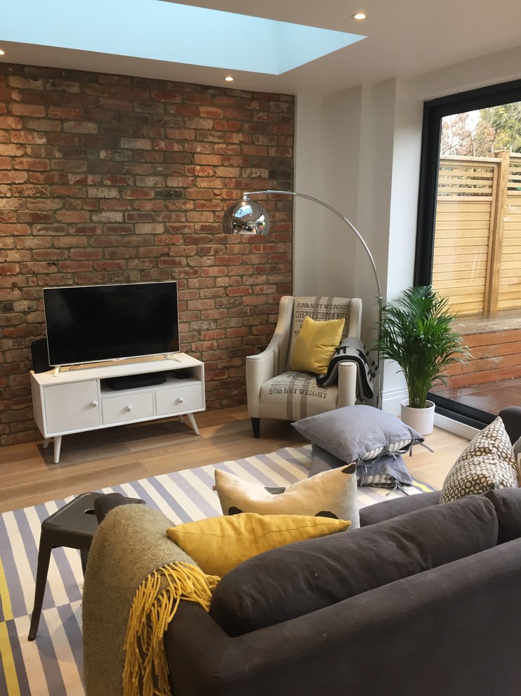 Mittelgroßes, Abgetrenntes Modernes Wohnzimmer mit weißer Wandfarbe, hellem Holzboden und freistehendem TV in London