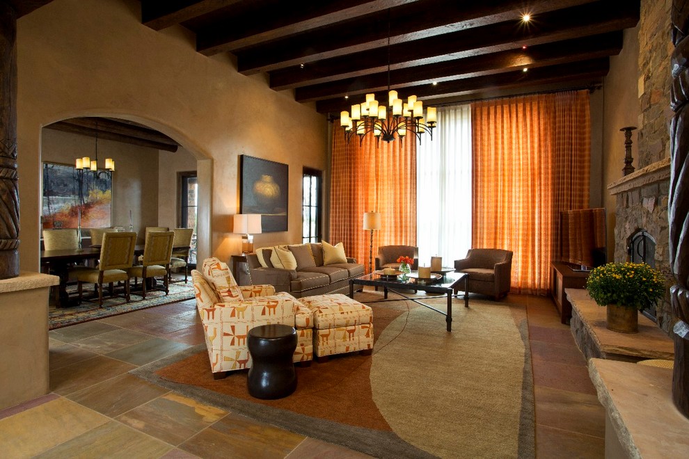 Esempio di un grande soggiorno tradizionale aperto con pareti gialle, camino classico, cornice del camino in pietra, nessuna TV e pavimento in ardesia