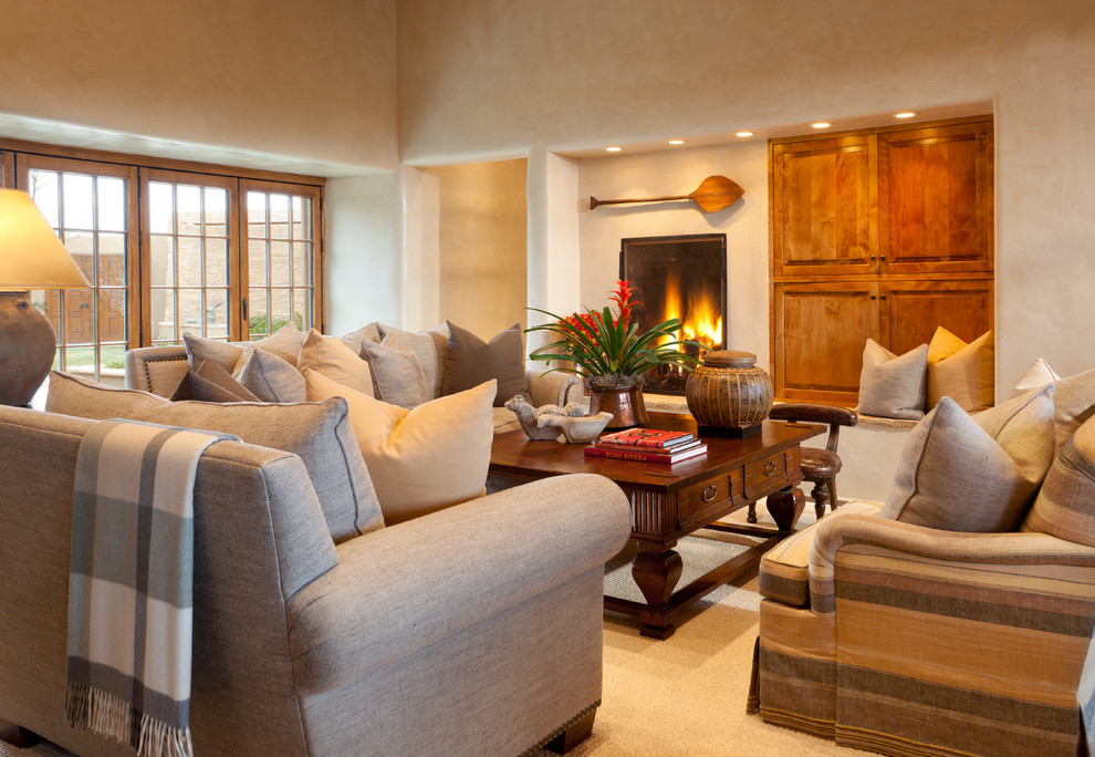 Living room - southwestern formal and open concept dark wood floor living room idea in Albuquerque with beige walls, a standard fireplace, a stone fireplace and no tv
