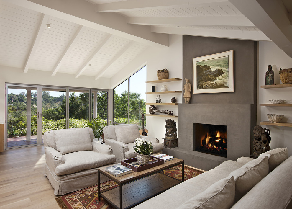 Cette image montre un salon design de taille moyenne et ouvert avec une cheminée standard, un manteau de cheminée en plâtre, un mur blanc, parquet clair et aucun téléviseur.