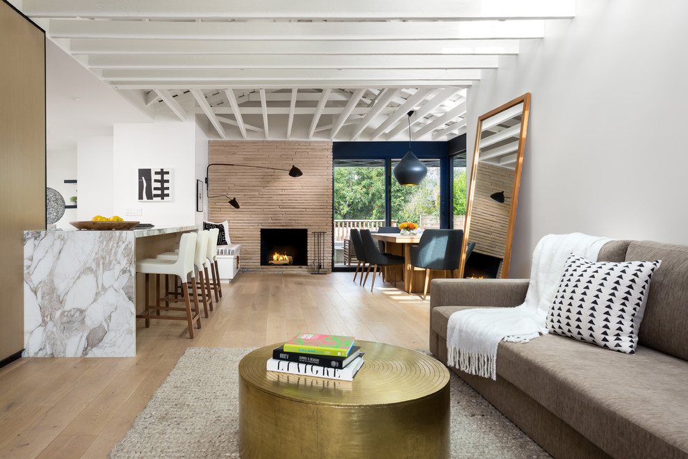 Inspiration for a mid-sized contemporary open concept light wood floor and beige floor living room remodel in Los Angeles with white walls, a standard fireplace, a stone fireplace and no tv