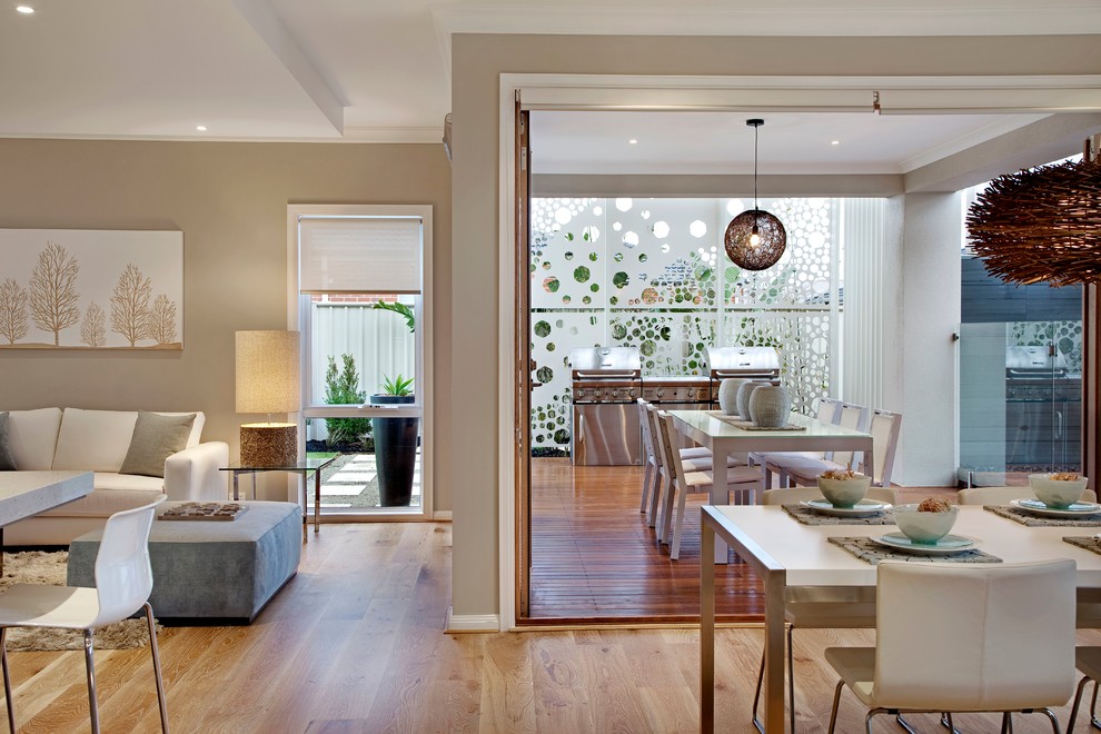 Offenes Modernes Wohnzimmer mit beiger Wandfarbe und braunem Holzboden in Melbourne
