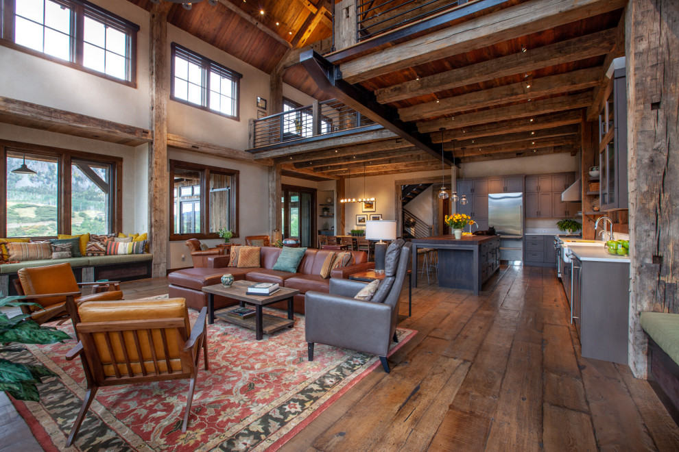 Inspiration for a large rustic formal open plan living room in Denver with beige walls, dark hardwood flooring, brown floors, a standard fireplace, a stone fireplace surround and a wall mounted tv.