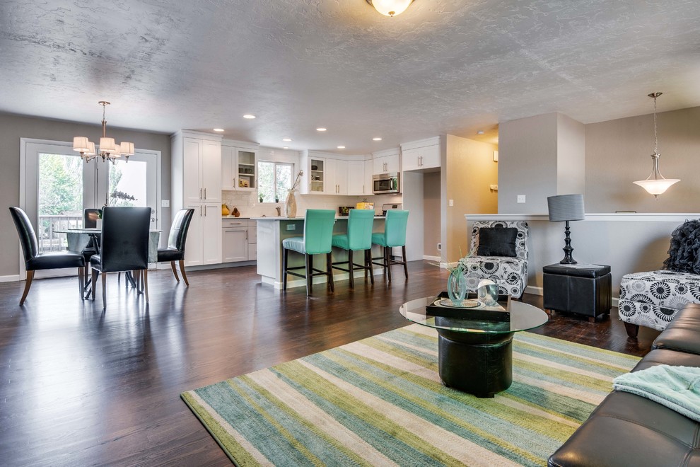 Mittelgroßes, Offenes Klassisches Wohnzimmer mit grauer Wandfarbe, dunklem Holzboden, Kamin und Kaminumrandung aus Backstein in Boise