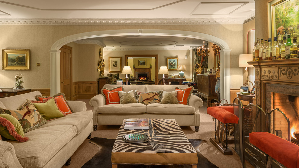 Immagine di un soggiorno tradizionale aperto con sala formale, pareti beige, moquette, camino classico, cornice del camino in mattoni e nessuna TV