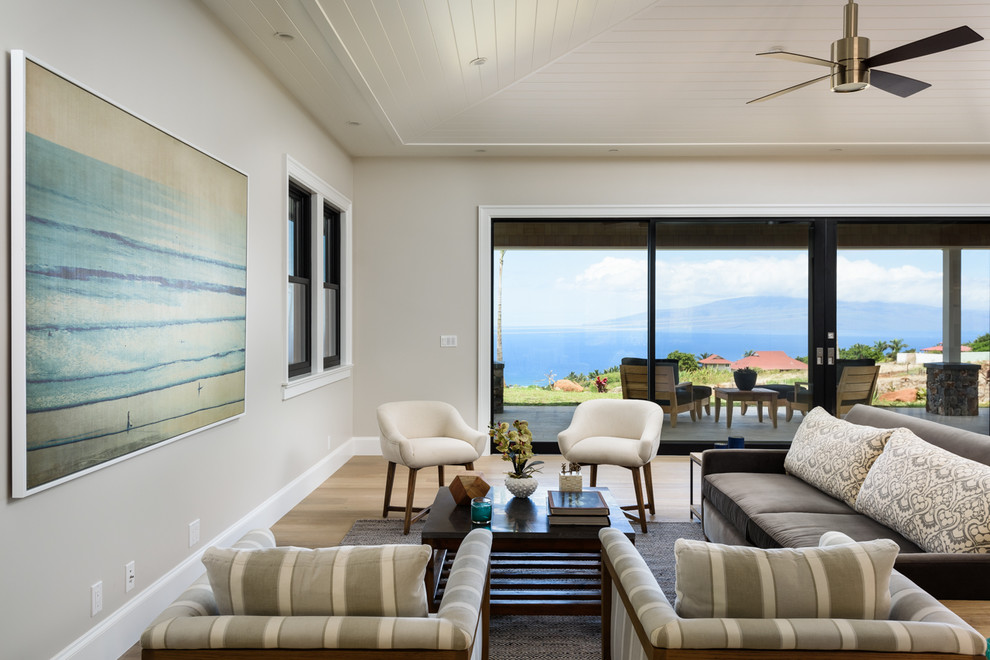 Immagine di un grande soggiorno stile marino aperto con pareti beige, parquet chiaro e nessun camino