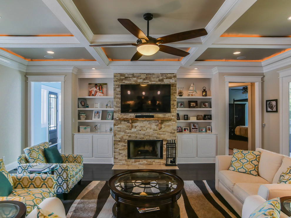 Inspiration for a large transitional open concept dark wood floor and brown floor living room remodel in Other with beige walls, a standard fireplace, a stone fireplace and a wall-mounted tv