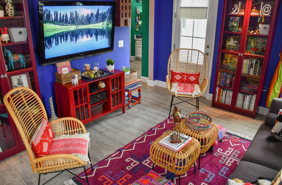 Cette image montre un grand salon bohème ouvert avec une salle de réception, un mur violet, un sol en carrelage de porcelaine, un téléviseur fixé au mur et un sol gris.