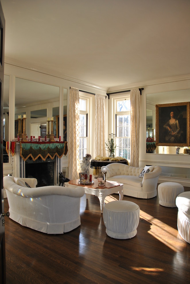 Exemple d'un très grand salon mansardé ou avec mezzanine rétro avec un bar de salon, un sol en bois brun, un manteau de cheminée en plâtre, un mur blanc et une cheminée d'angle.