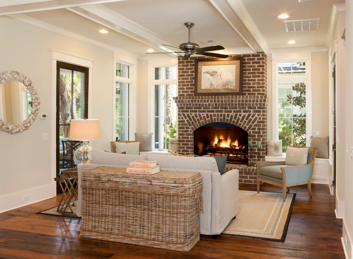 Example of a mid-sized beach style enclosed medium tone wood floor living room design in Charleston with beige walls, a standard fireplace and a brick fireplace