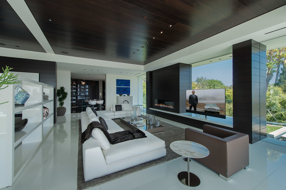 Свежая идея для дизайна: огромная парадная, двухуровневая гостиная комната в белых тонах с отделкой деревом в стиле модернизм с стандартным камином, отдельно стоящим телевизором, белым полом и многоуровневым потолком - отличное фото интерьера