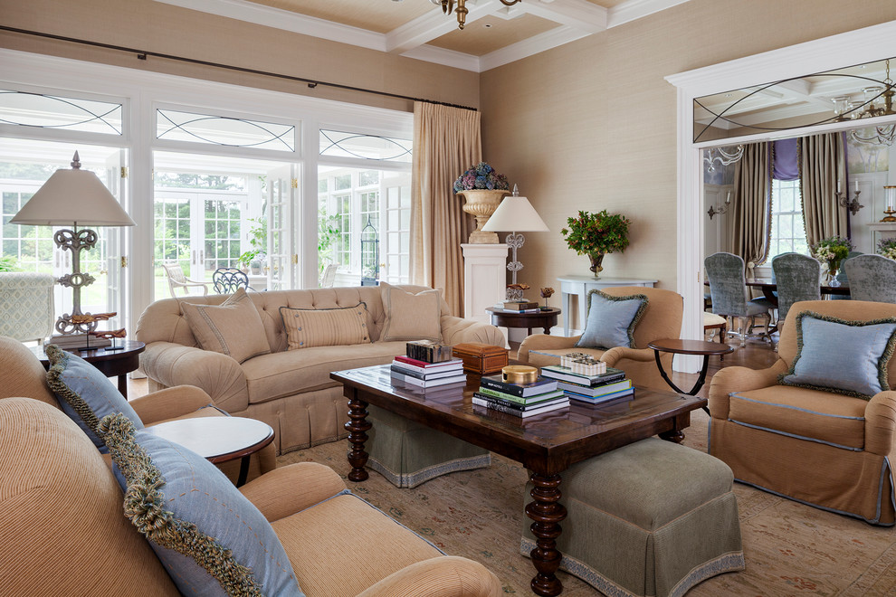 На фото: изолированная гостиная комната в классическом стиле с бежевыми стенами и коричневым диваном с