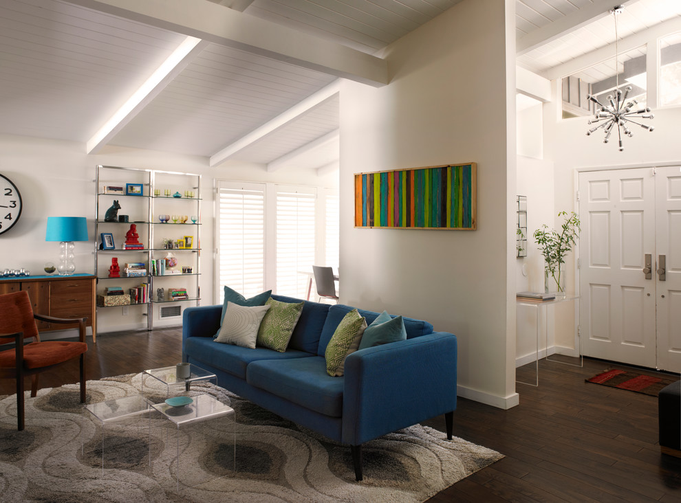 Offenes Retro Wohnzimmer mit weißer Wandfarbe und dunklem Holzboden in Los Angeles