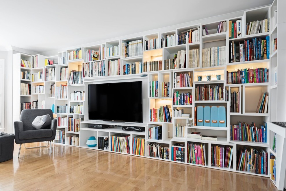 Mittelgroße, Offene Moderne Bibliothek ohne Kamin mit beiger Wandfarbe, hellem Holzboden, TV-Wand und braunem Boden in Montreal