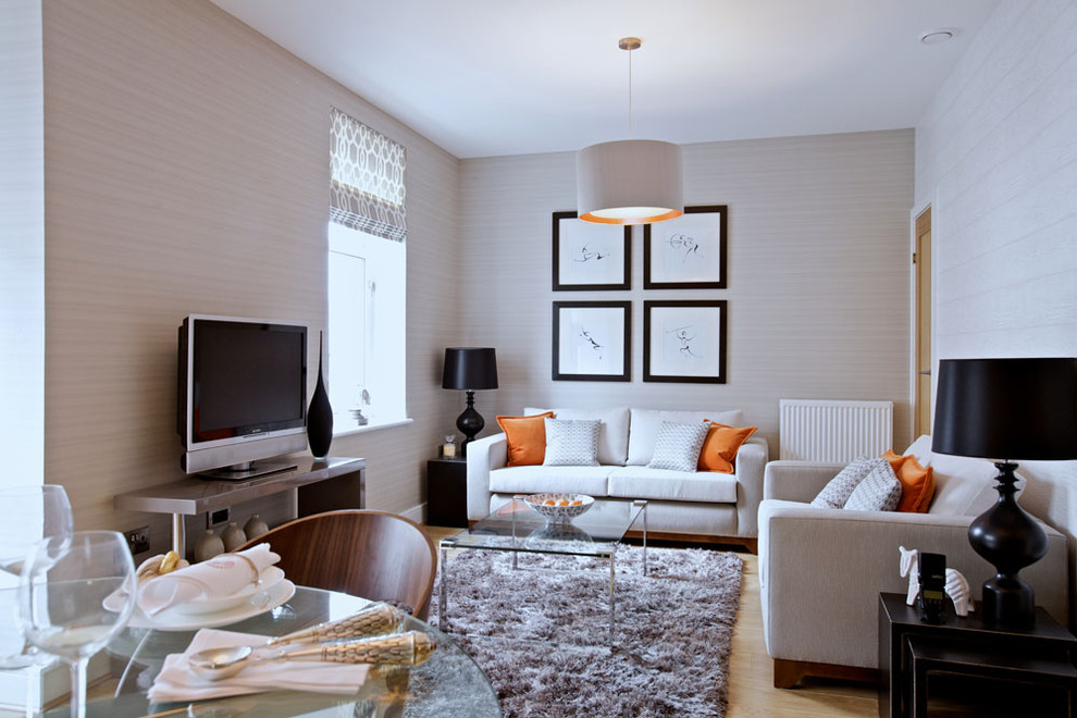 Example of a trendy light wood floor living room design in Edinburgh with beige walls and a tv stand