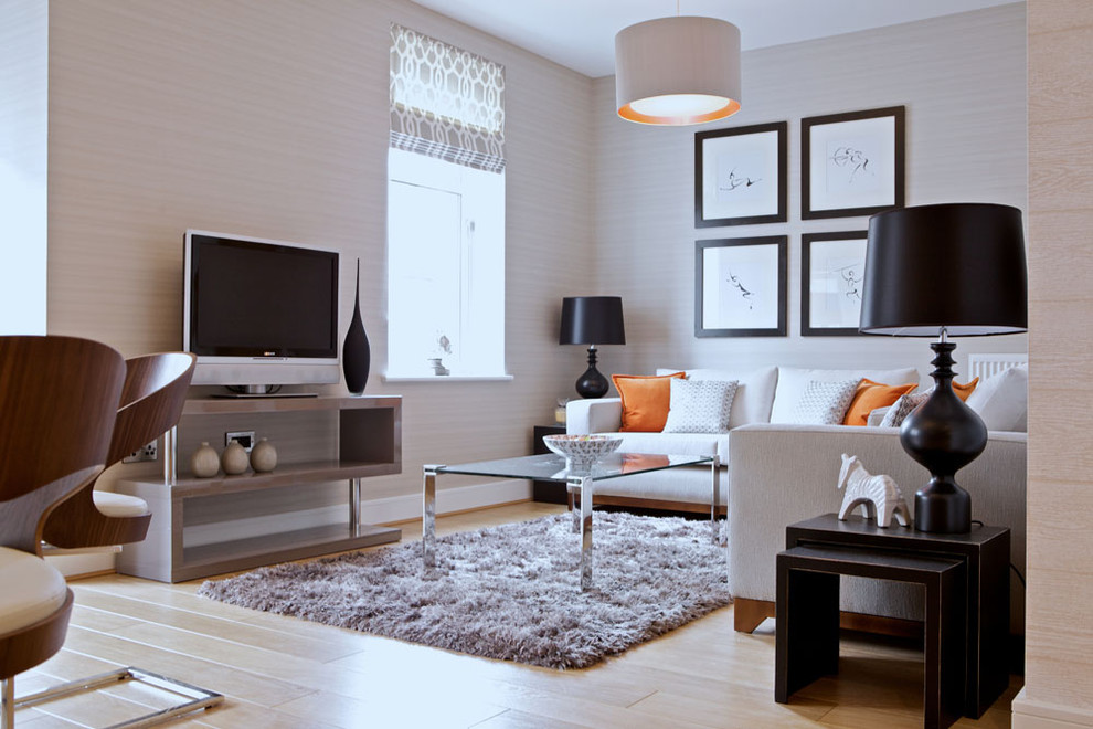 Immagine di un soggiorno minimal con pareti beige, parquet chiaro, TV autoportante e tappeto