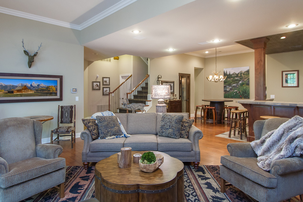 Großes, Offenes Uriges Wohnzimmer mit beiger Wandfarbe, braunem Holzboden, Eckkamin, Kaminumrandung aus Stein und braunem Boden in Kansas City