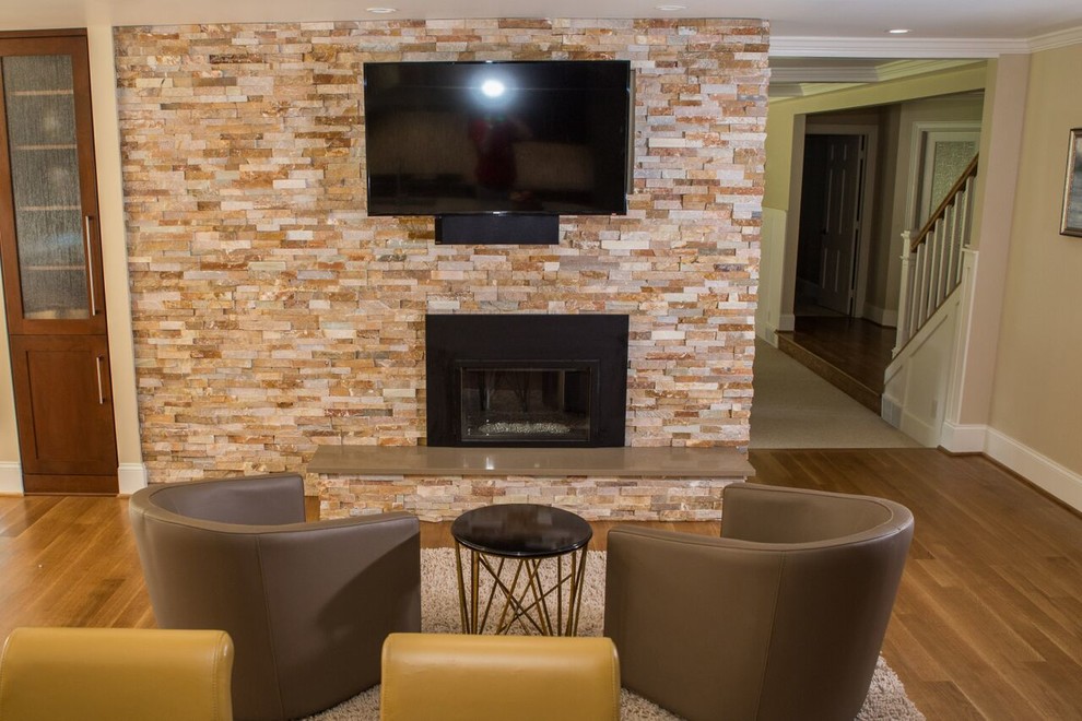 Immagine di un ampio soggiorno classico aperto con pareti beige, parquet chiaro, camino classico, cornice del camino in legno e TV a parete