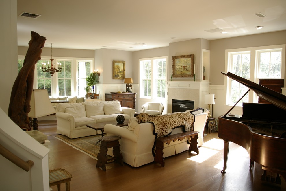На фото: открытая гостиная комната среднего размера в стиле кантри с музыкальной комнатой, серыми стенами, паркетным полом среднего тона, стандартным камином и фасадом камина из дерева
