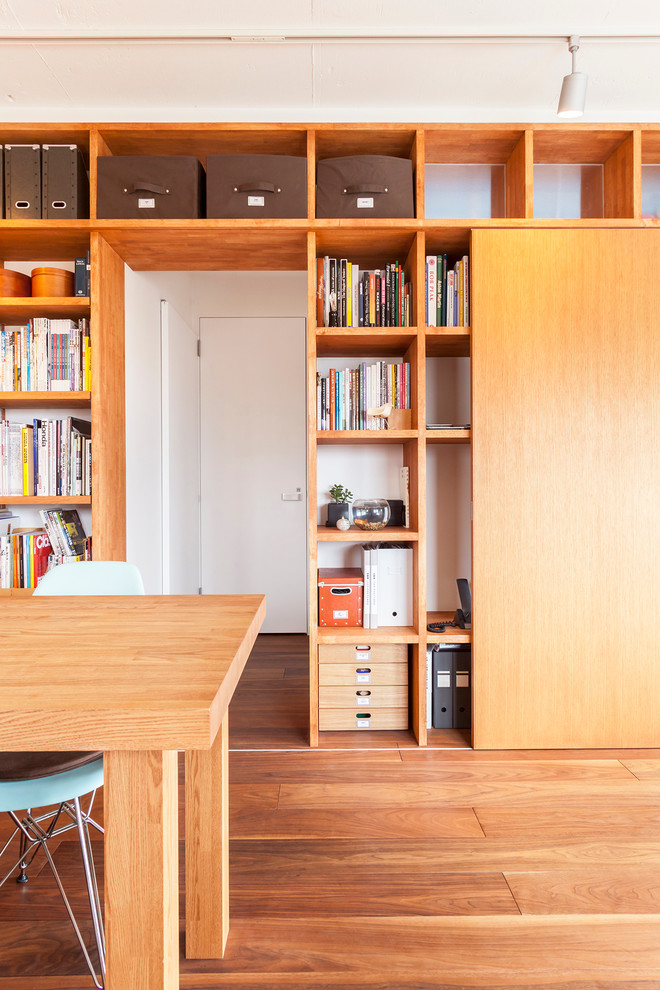 Mittelgroßes, Repräsentatives, Offenes Wohnzimmer ohne Kamin mit weißer Wandfarbe, braunem Holzboden und freistehendem TV in Tokio