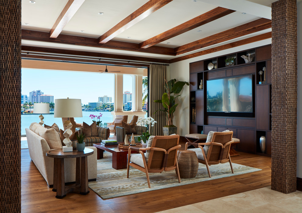 Стильный дизайн: гостиная комната в морском стиле с белыми стенами, паркетным полом среднего тона, телевизором на стене и коричневым полом - последний тренд
