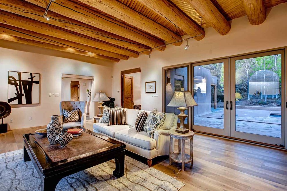 Ejemplo de salón cerrado de estilo americano sin televisor con paredes beige, suelo de madera en tonos medios, todas las chimeneas y marco de chimenea de piedra