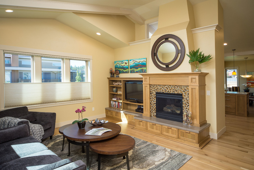 Mittelgroßes, Offenes Uriges Wohnzimmer mit beiger Wandfarbe, braunem Holzboden, Kamin, Kaminumrandung aus Holz und Multimediawand in Portland