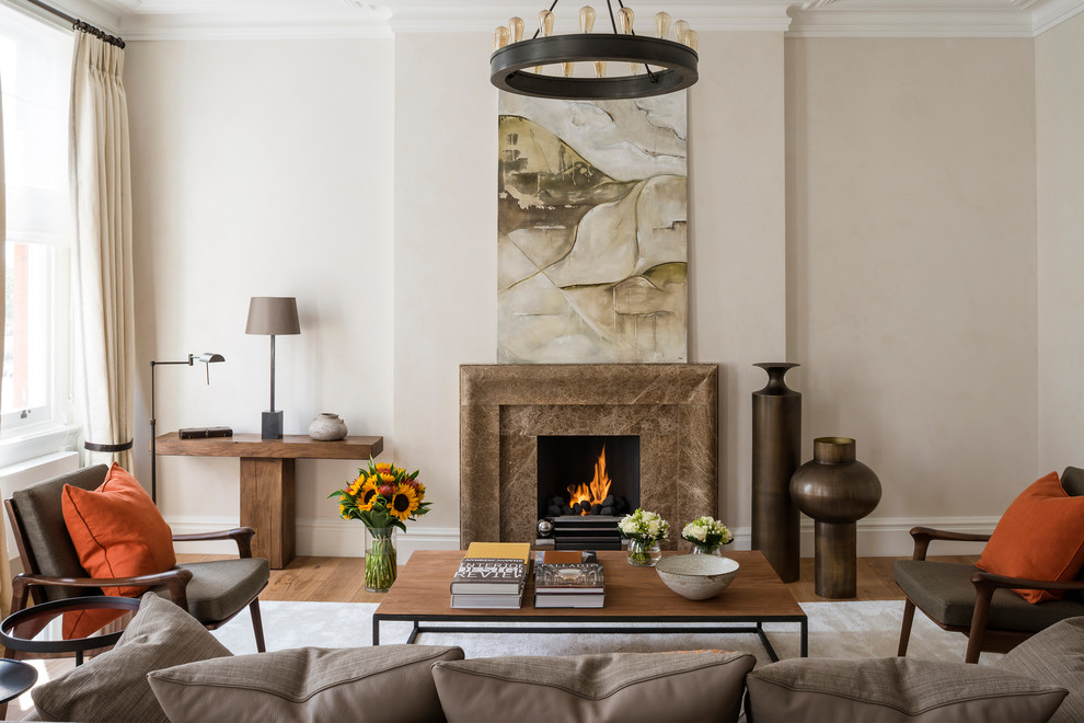 Traditional formal living room in London with beige walls and a standard fireplace.