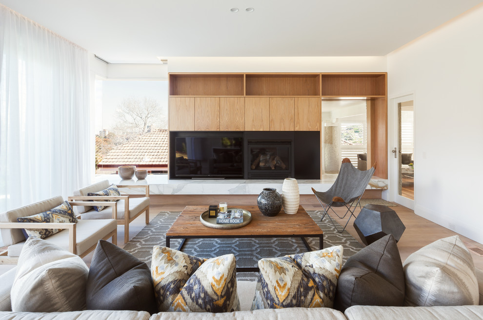 Example of a mid-sized danish open concept living room design in Sydney with white walls, a standard fireplace and a tv stand