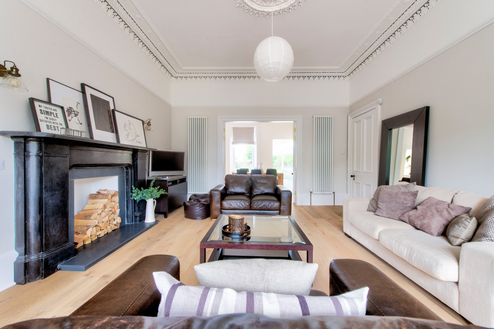 Großes, Abgetrenntes Klassisches Wohnzimmer mit beiger Wandfarbe, hellem Holzboden, Kamin, Kaminumrandung aus Stein, freistehendem TV und beigem Boden in Glasgow